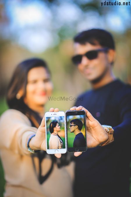 Photo of Unique pre wedding shot with photos on cellphone