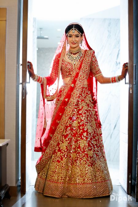 Red and gold bridal lehenga with sequin work all over