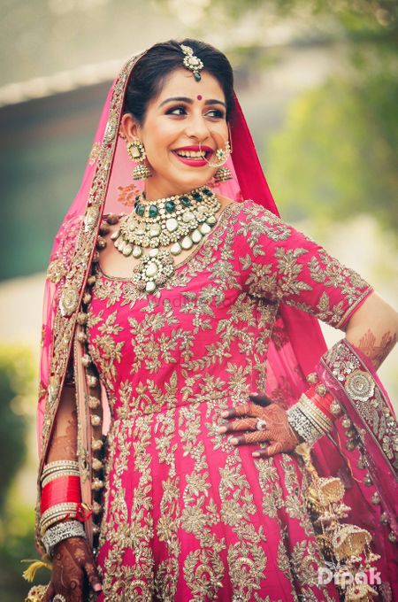 Contrasting bridal jewellery with pink anarkali on sikh bride