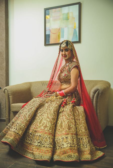 Gold embroidered lehenga with contrasting red dupatta