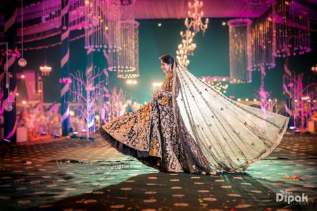 Bride twirling in dark lehenga with long dupatta