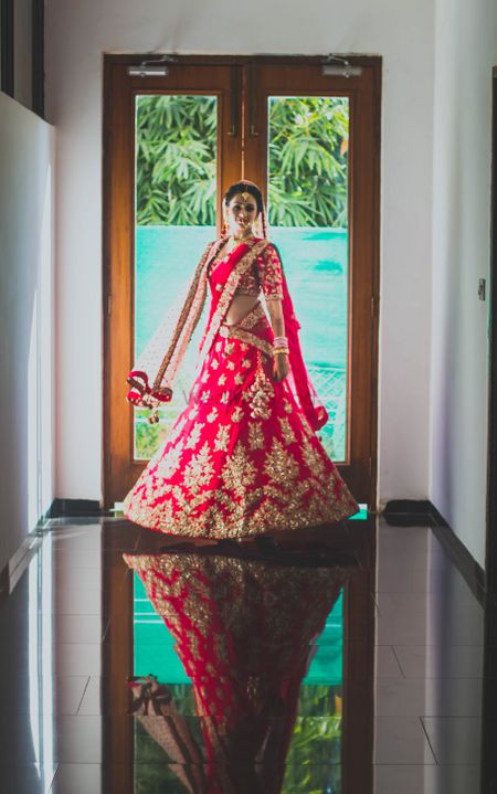 Twirling bride in red and gold lehenga