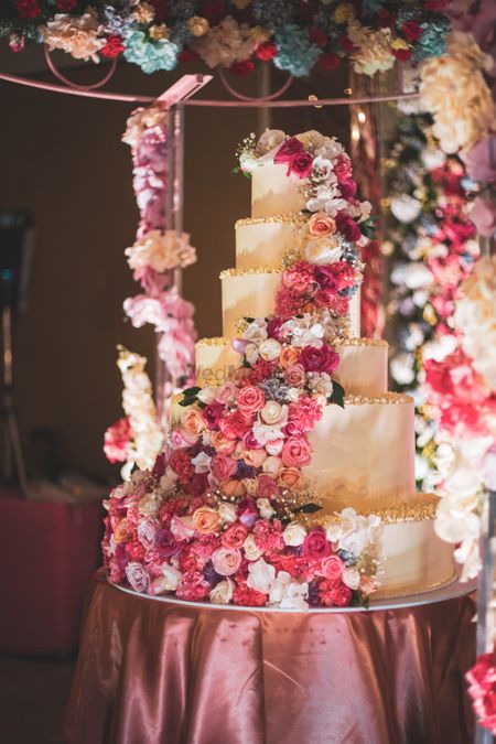 Huge wedding cake with floral decorations on top.