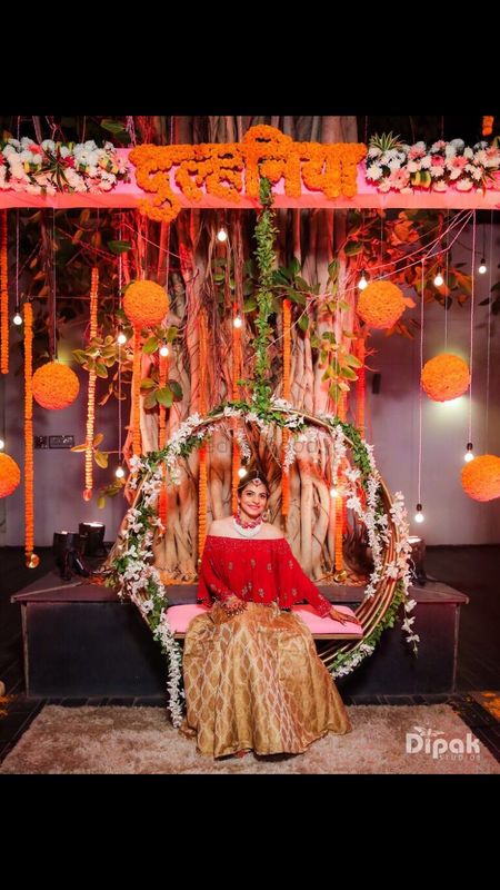 Mehendi decor ideas with bride on bridal jhoola