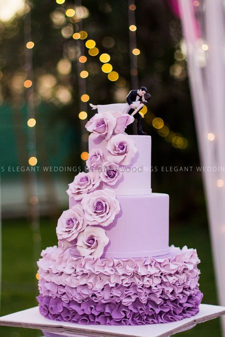 Photo of Ombre lavender 3 tiered wedding cake with bride and groom topper
