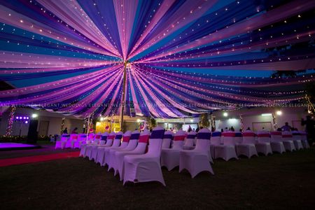 Photo of Night wedding decor idea with purple and blue tent