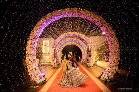 Couple shot under grand arch floral decor 