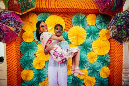 Holi party for mehendi with bride and groom against photobooth