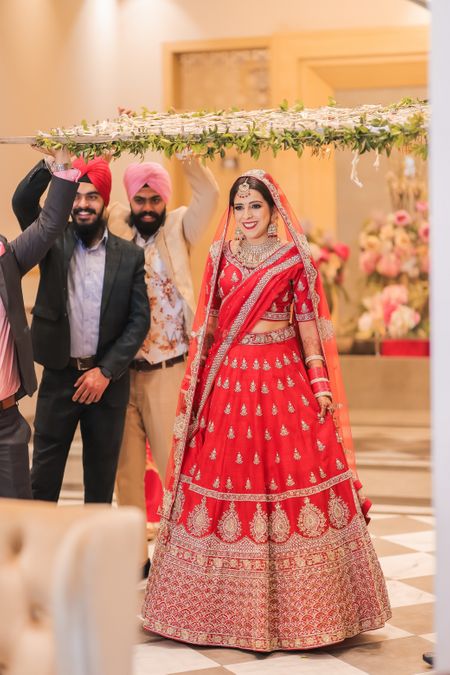 bride making her entry in a bright red lehenga