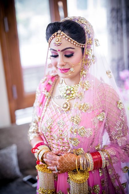 Sikh bride in light pink lehenga wearing kale eras