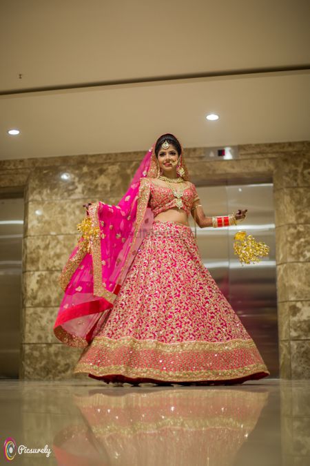 Hot pink Sabyasachi bridal lehengas with gold motifs