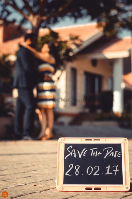 Chalkboard save the date idea with couple in the background