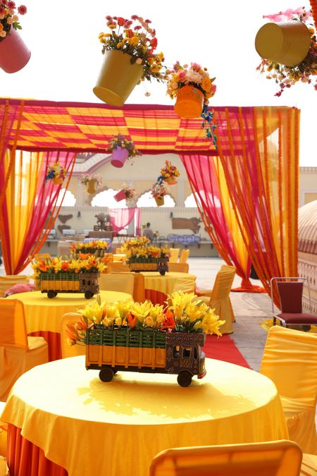 Photo of Hanging flower pots and decorated mini trucks as props for mehendi decor