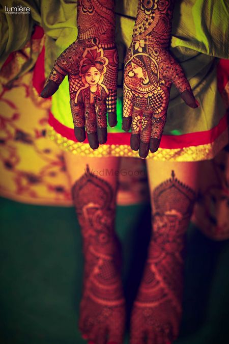 Mehendi design with bride and groom portraits on hands