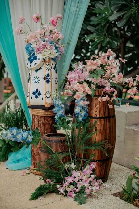 A cozy corner bedecked with wooden drums and floral arrangements