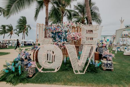 Photo backdrop created with huge monograms, wooden boxes and florals.