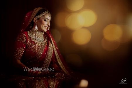 Candid shot of a bride dressed in a red lehenga.