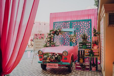 Photo of A car photobooth with some wooden boxes and floral arrangements.