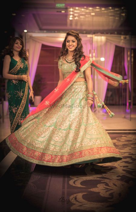 Bride twirling in red and turquoise lehenga