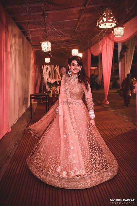 Twirling bride in shimmery peach and gold net anarkali