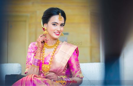 South Indian bride in pink wearing temple jewellery