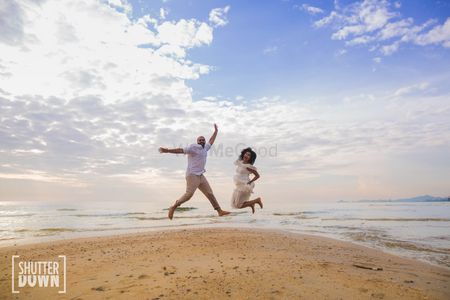 Beach pre wedding shoot with couple jumping shot