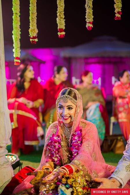 Happy bride shot wearing light pink lehenga