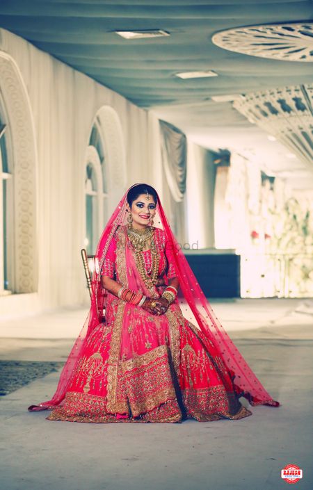 Photo of Red bridal lehenga with gold chandelier design embroidery