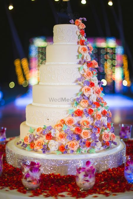 Colorful cakes on 6 tier white wedding cake