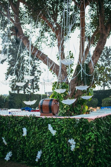 Backyard decor idea with hanging lace umbrella and beer barrel