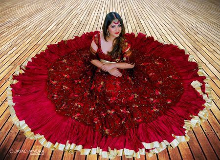 Bride with maroon flared lehenga on the floor