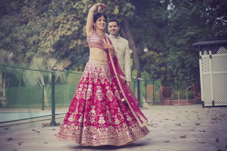 Bride twirling in red bridal lehenga with white embroidery