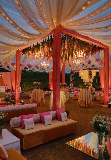 Photo of Red and gold mandap with hanging florals