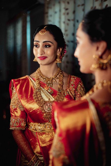 Bride wearing red and white saree with temple jewellery.