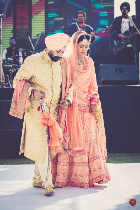 Coordinated bride and groom in peach wedding outfit and turban