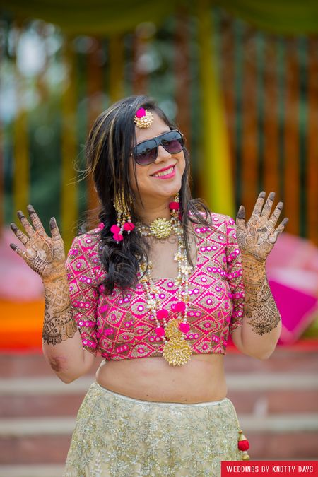 Bride in pink wearing shades and pompom gota jewellery 