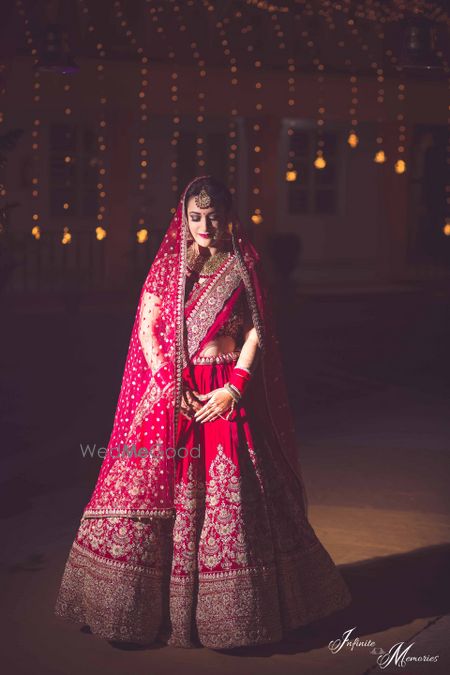 Bride posing in deep red bridal lehenga with threadwork