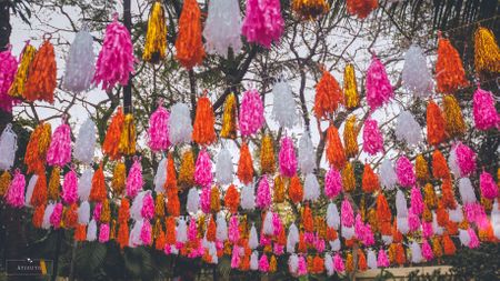 Photo of Mehendi decor idea with hanging orange and pink tassels