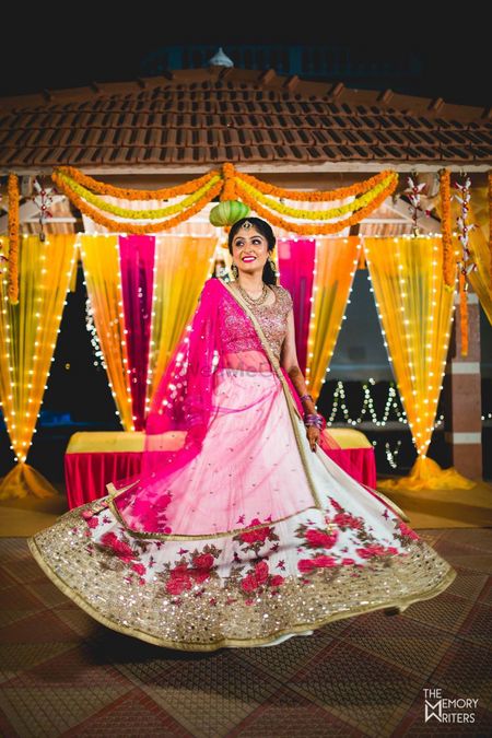 Photo of Bride twirling in pink and white floral lehenga