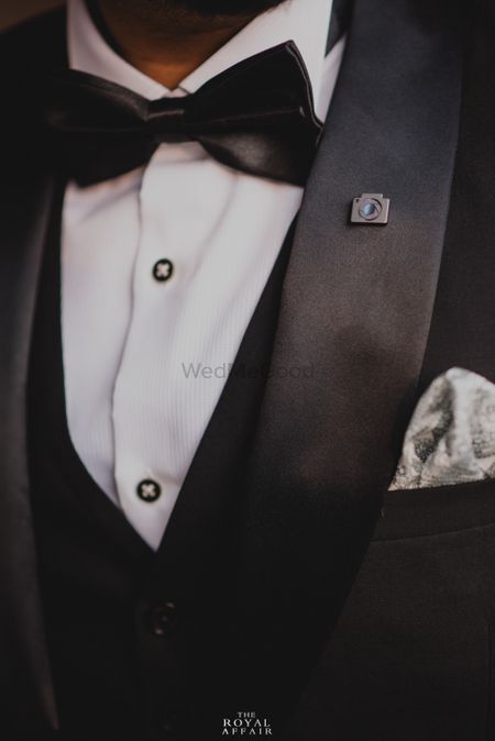 Photo of Unique groom accessory with camera lapel pin