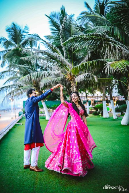 Bright pink engagement lehenga with twirling bride