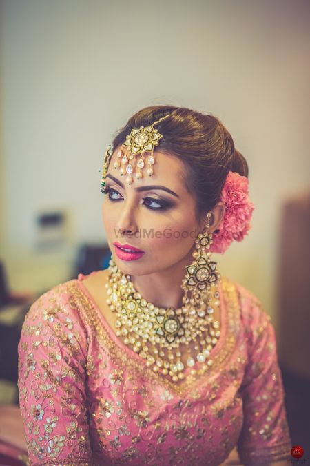 Bridal hair and makeup with light pink lehenga
