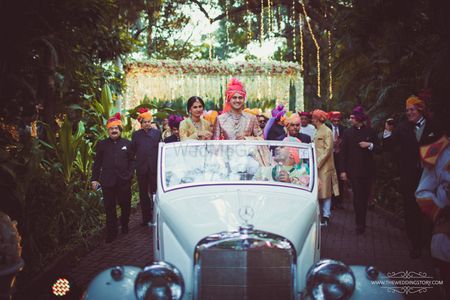 Photo of Groom entering in a white vintage car