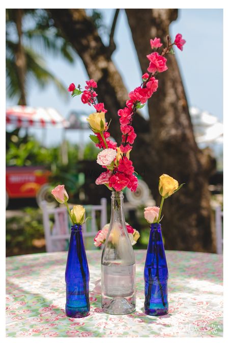 Glass bottle as vases with flowers for boho wedding decor