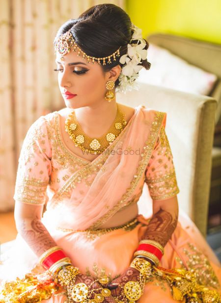 Gold bridal jewellery with light pink lehenga