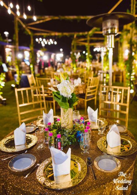 Photo of Pretty table setting with floral table centerpiece and gold plated cutlery