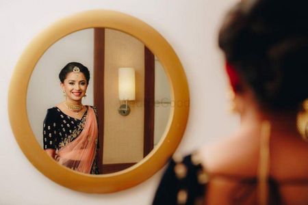 Photo of Bridal portrait with bride looking in mirror