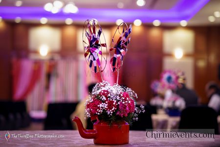 Photo of Floral tea kettle with colorful paper wheels as table centerpiece