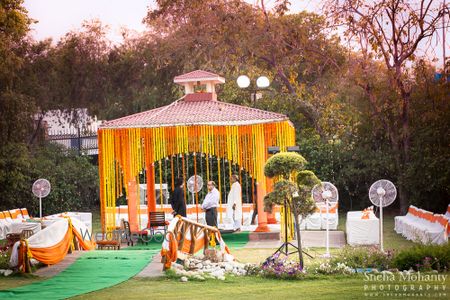 Photo of yellow and orange flower decorate mandap