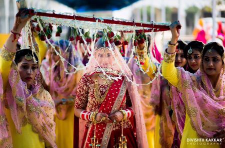 Unique bridal entry with bridesmaids holding chadar
